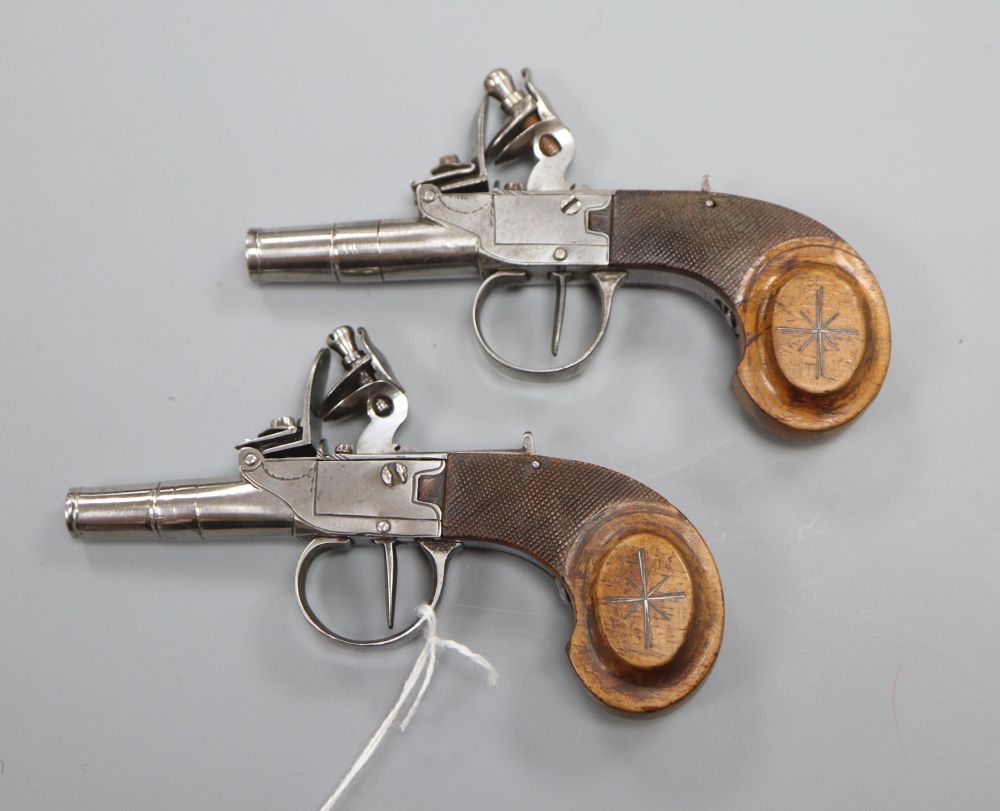 A pair of Continental flintlock pocket pistols, with silver wire inlaid walnut grips